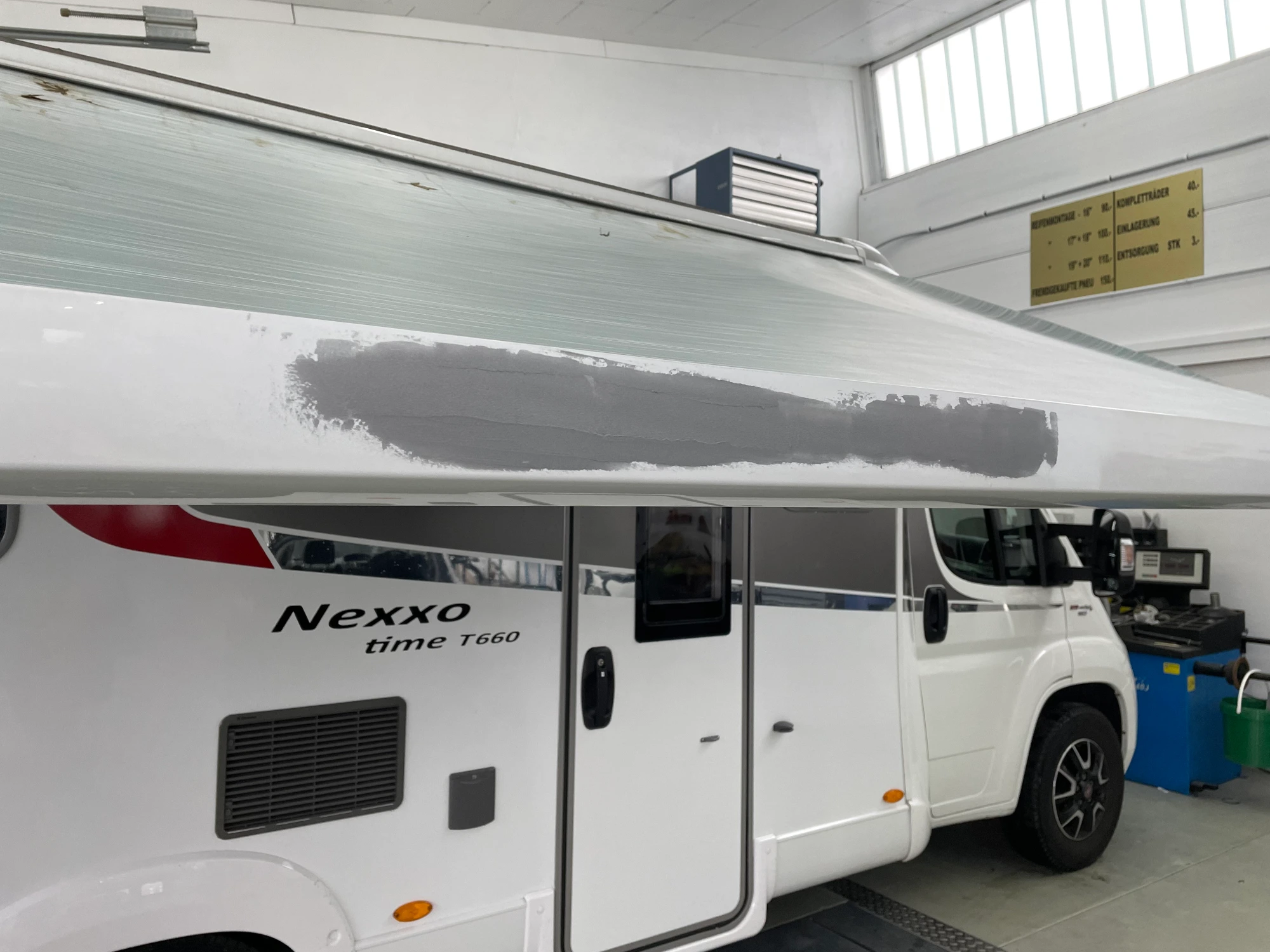 Ein Wohnmobil dessen Sonnendach mitten in der Reparatur steckt.