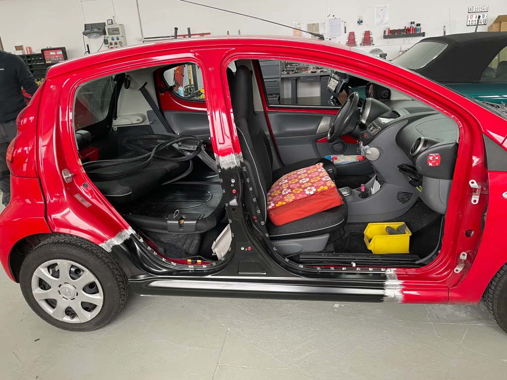 Ein roter Peugeot kleinere Größe inmitten von Reparaturarbeiten.